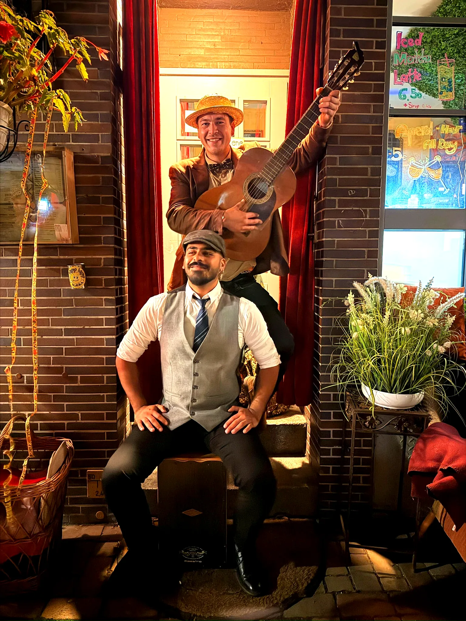 Die Musiker Habbibi Hermanos sitzen gemeinsam vor einem Café