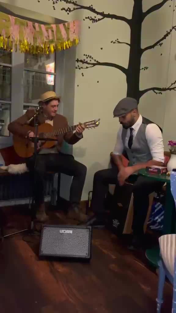 Die beiden Musiker während einer Live-Session mit Gitarre und Cajón